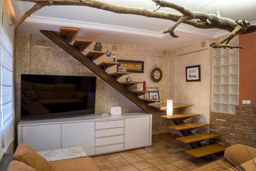 a living room with a large tv and a staircase at Casa vacaciones in Castellón de la Plana