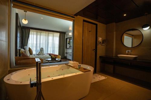 a large bathroom with a tub and a sink at Saugandhika West Gate in Wayanad