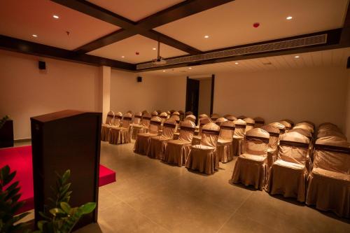 a row of chairs in a room with a row of tables at Saugandhika West Gate in Wayanad