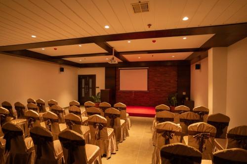 a conference room with chairs and a screen in it at Saugandhika West Gate in Wayanad