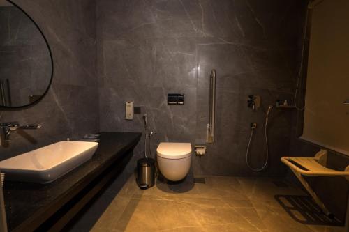 a bathroom with a toilet and a sink and a shower at Saugandhika West Gate in Wayanad
