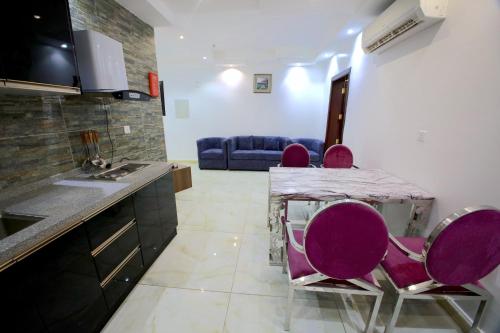 a kitchen with purple chairs and a table and a couch at Developed view Hotel in Jeddah