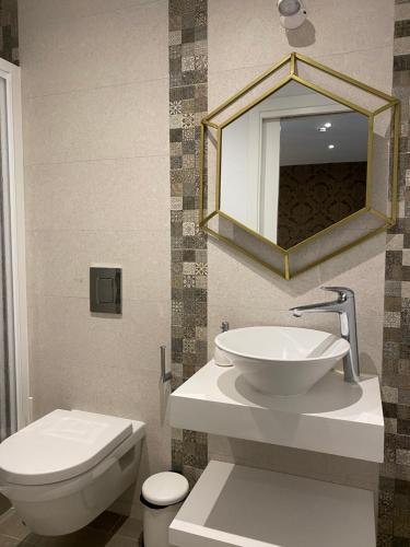a bathroom with a sink and a toilet and a mirror at Hostal El Caprichito Marbella in Marbella