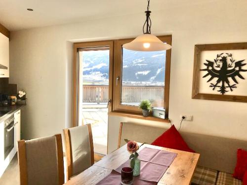 a dining room with a table and a window at Restaurant Appartements Almdiele in Hart im Zillertal