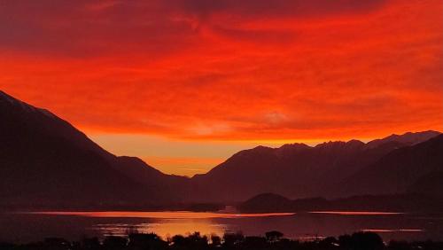a sunset over a body of water with mountains at Bed and Breakfast Studios Alto lago di Como in Gravedona