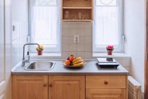 a kitchen with a bowl of fruit on a counter at Apartman Ady 6 in Senta