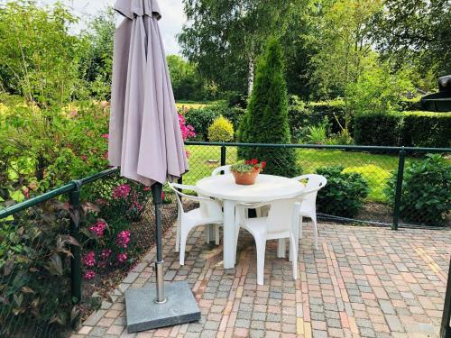 a table and chairs and an umbrella on a patio at Holiday Home Noordwolde Countryside in Noordwolde