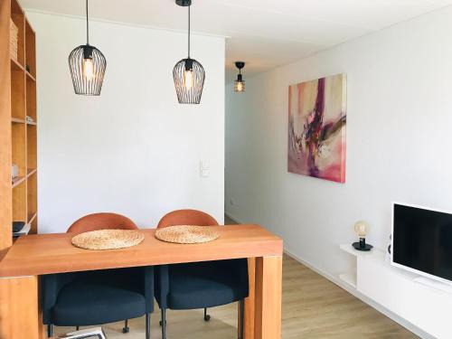 a dining room with a table and chairs and a tv at Holiday Home Noordwolde Countryside in Noordwolde