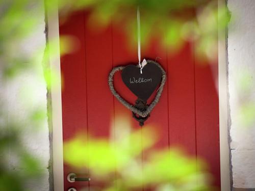 a heart hanging on a red door at Scenic Gulp Valley Stay in Slenaken