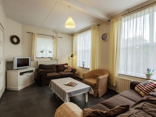 een woonkamer met een bank en een tv bij from the Zealand coast and 20km from Brugge in Aardenburg