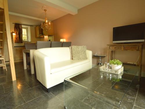 a living room with a white couch and a table at Holiday Home in Slenaken near Forest in Slenaken