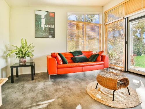 um sofá laranja numa sala de estar com janelas em Fantastic modern vacation home with views em Tripscompagnie