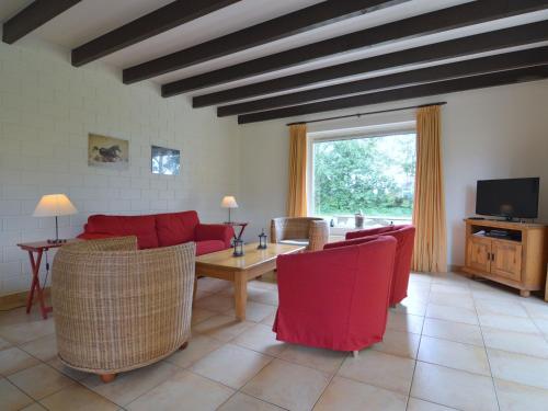 ein Wohnzimmer mit einem roten Sofa und einem Tisch in der Unterkunft Holiday home with view over the meadows in Kibbelveen