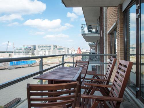 a wooden table and chairs on a balcony with a view at Apartment overlooking the Scheveningen harbor in Scheveningen