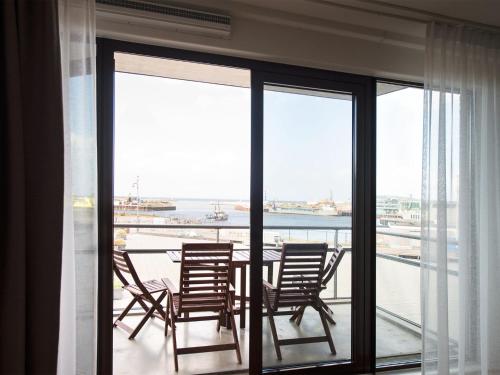 a dining room with a table and chairs on a balcony at Apartment overlooking the Scheveningen harbor in Scheveningen