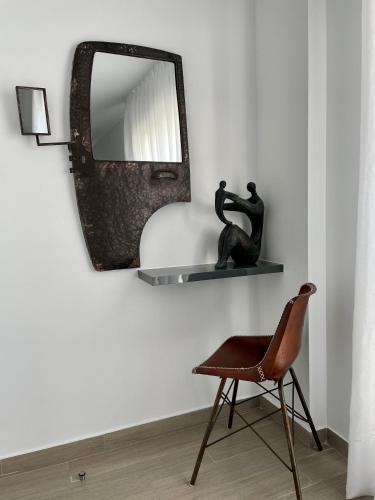 a chair and a mirror on a wall at Hostal El Caprichito Marbella in Marbella