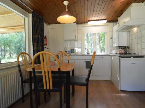 a kitchen with a wooden table and chairs in a kitchen at Holiday Home in Stramproy near Nature Reserve in Stramproy