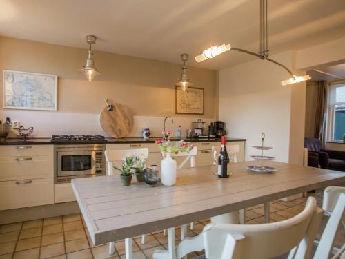 duża kuchnia z drewnianym stołem i krzesłami w obiekcie Spacious holiday home in Groede w mieście Groede