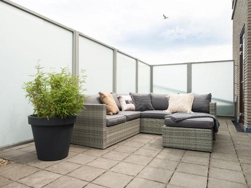 a balcony with two couches and a potted plant at Sea view apartment in Den Haag with terrace in Scheveningen