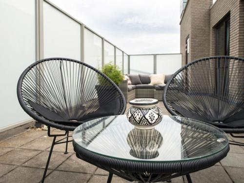 a glass table and chairs on a balcony at Sea view apartment in Den Haag with terrace in Scheveningen