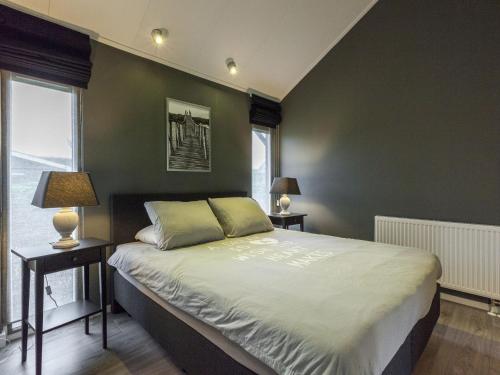 1 dormitorio con paredes verdes y 1 cama con 2 lámparas en Holiday home with lovely terrace, en Kattendijke
