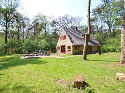 una casa en un patio con una mesa de picnic en Detached holiday home surrounded by nature, en Zuidwolde