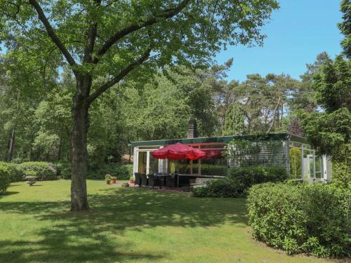 a house in a garden with a tree at Beautiful Holiday Home with Garden in Huijbergen in Huijbergen