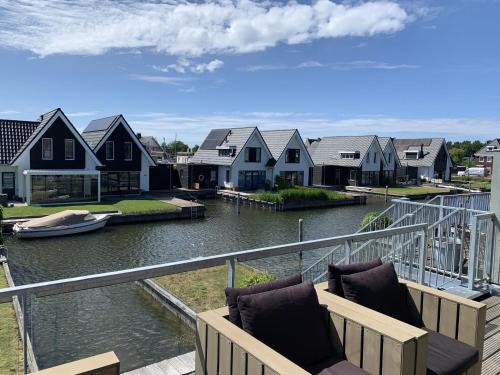 スタフォーレンにあるLovely Holiday Home in Stavoren near Frisian Lakesの家屋のある川の景色を望むバルコニー
