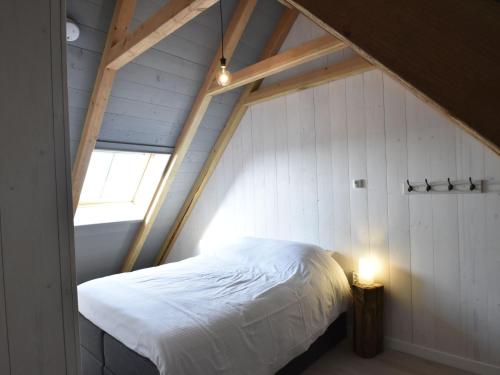 an attic bedroom with a bed and a window at Holiday Home in Holland near Beaches in Callantsoog