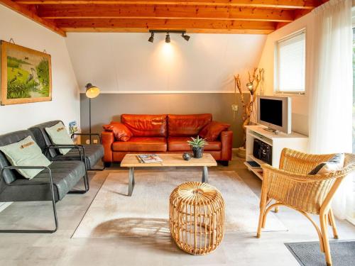 uma sala de estar com um sofá de couro e uma televisão em Modern Holiday Home in Friesland by the Lake em Anjum