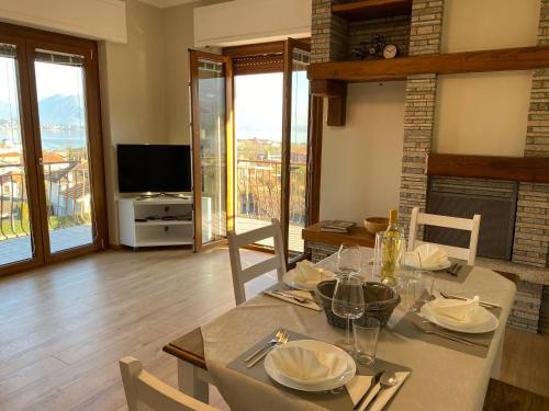 a dining room with a table with chairs and a television at Appartamento Golfo Borromeo 1 Baveno in Baveno
