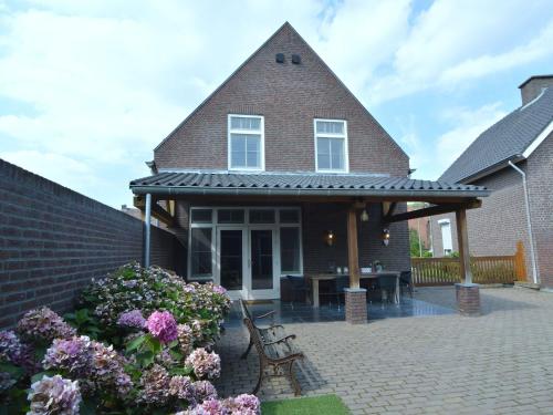 uma casa com um pátio com bancos e flores em Luxury apartment in Posterholt with a terrace em Posterholt