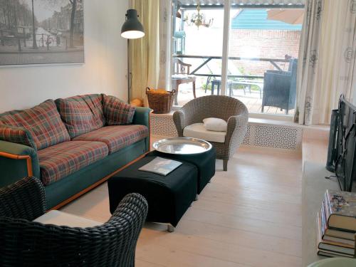 uma sala de estar com um sofá, cadeiras e uma mesa em Lovely Holiday Home in Noordwijkerhout near Lake em Noordwijkerhout