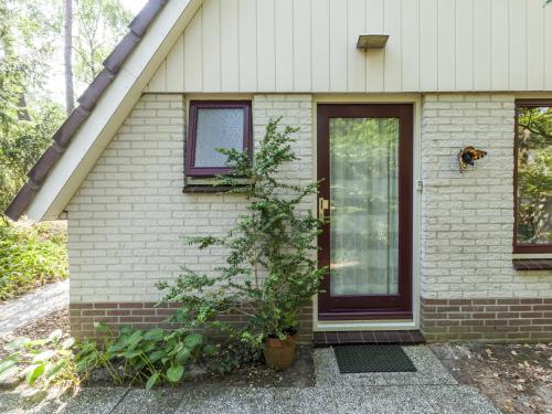 uma casa com uma porta e uma árvore em frente em Comfortable holiday home in Nunspeet em Nunspeet