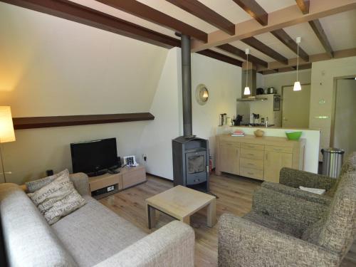 - un salon avec un canapé et une cuisinière dans l'établissement Cosy Holiday Home in Limburg with Forest nearby, à Stramproy