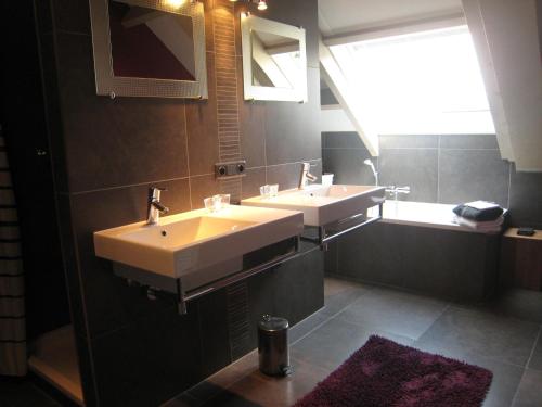a bathroom with two sinks and a large window at These two holiday homes built in 2006 in Zuidzande