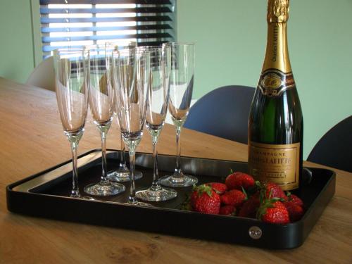 a tray with champagne glasses and strawberries on a table at These two holiday homes built in 2006 in Zuidzande