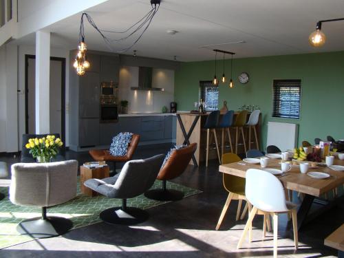 a kitchen and living room with a table and chairs at These two holiday homes built in 2006 in Zuidzande