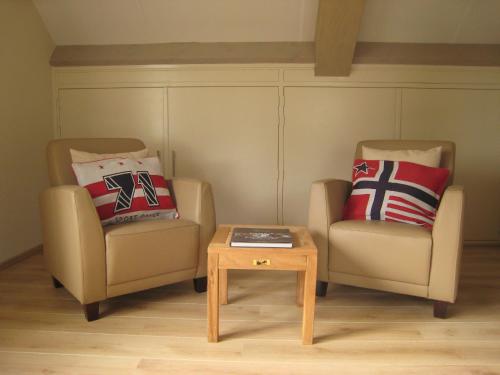 two chairs and a coffee table in a room at These two holiday homes built in 2006 in Zuidzande