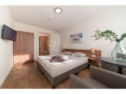 a bedroom with a large bed and a table at Modern Cottage with Sauna in Colijnsplaat in Colijnsplaat