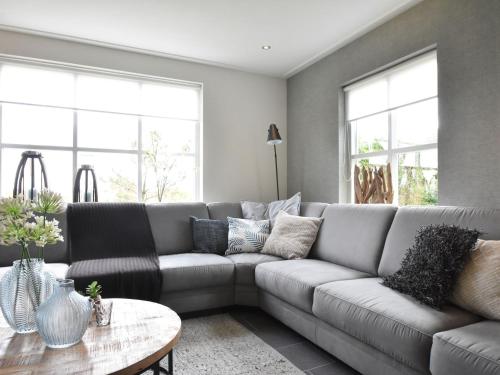 een woonkamer met een bank en een tafel bij Lavish Villa in Julianadorp aan zee with Sauna in De Zandloper