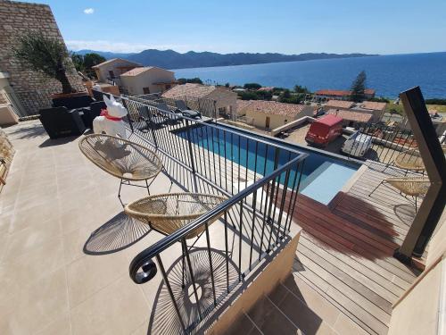 d'un balcon avec des chaises et une vue sur l'eau. dans l'établissement Domaine A Mortella T3, à Saint-Florent