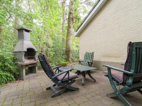 un patio con 2 sillas de césped y fogones en Elite Holiday Home in North Holland near Forest, en Schoorl
