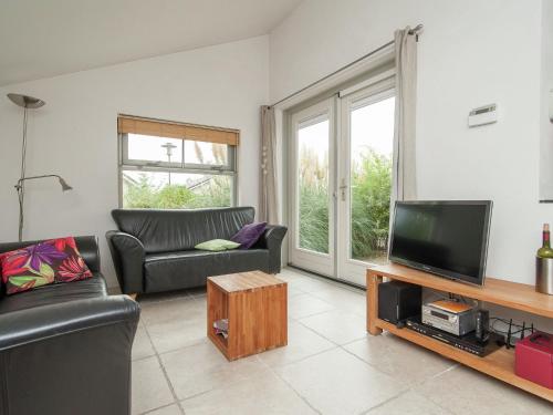 sala de estar con sofá y TV en Elite Holiday Home in North Holland near Forest, en Schoorl