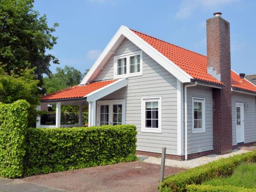 ノールトウェイクにあるStunning Holiday Home in Noordwijk near Beachのオレンジ色の屋根の白い家