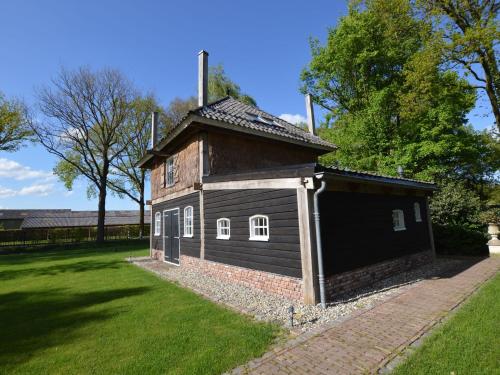 um pequeno edifício num quintal com um campo de relva em Cozy Holiday Home in Volkel with Sauna em Volkel