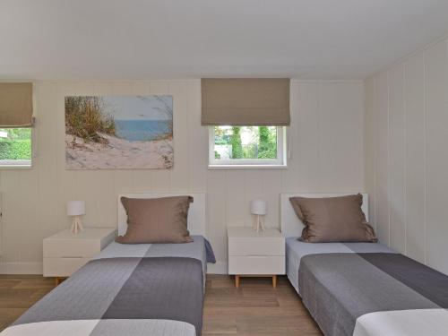 two beds in a room with two windows at Holiday Home in Kamperland by Veerse Meer in Kamperland