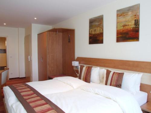 a bedroom with two beds with white sheets at Boutique Hotel Wolfsburg in Wolfsburg