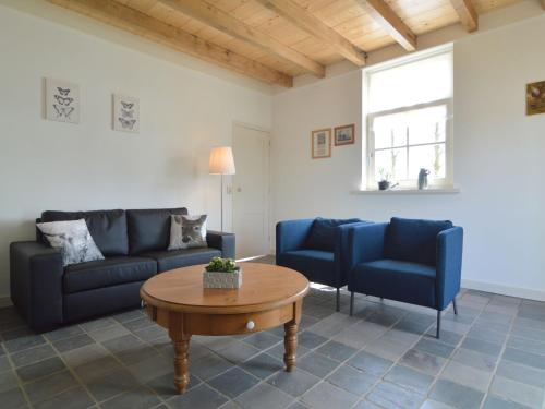 a living room with a couch and chairs and a table at Picturesque Holiday Home in Drimmelen with Garden in Hooge Zwaluwe