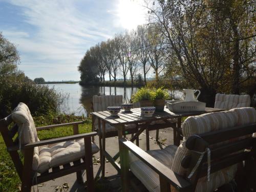 a table and chairs with a view of a lake at Picturesque Holiday Home in Drimmelen with Garden in Hooge Zwaluwe